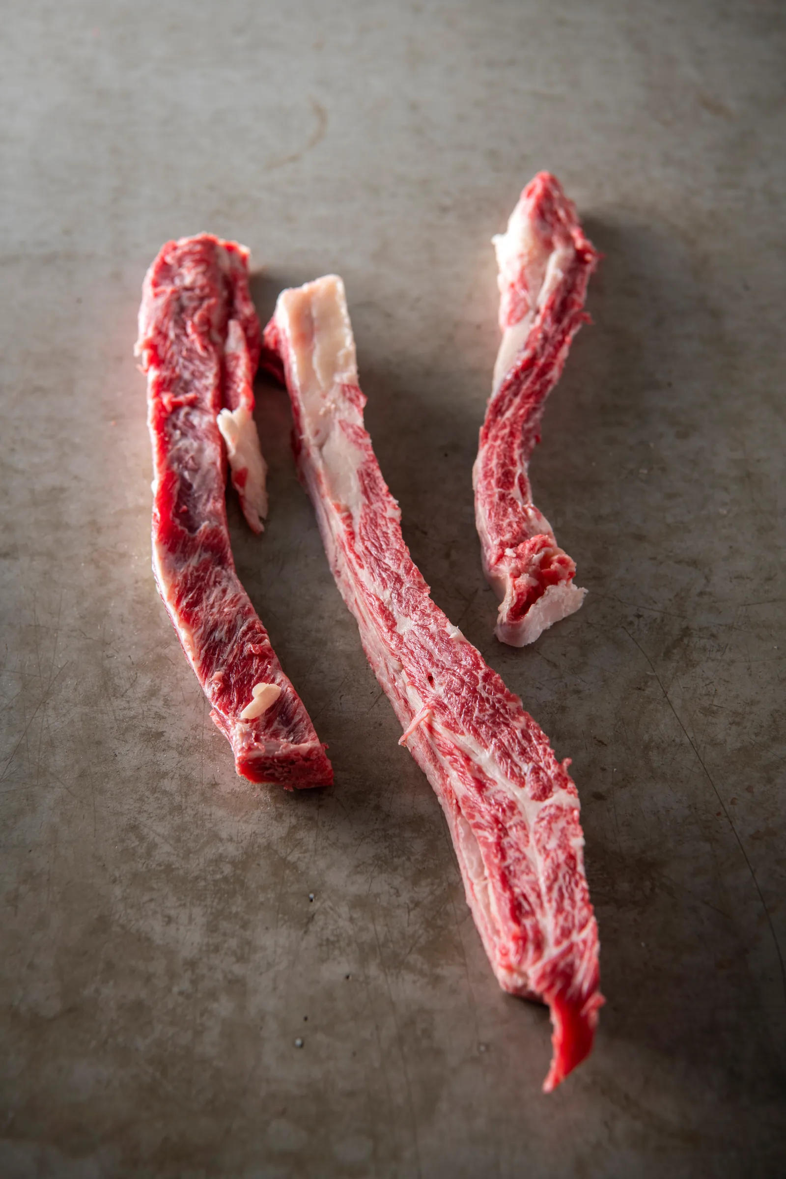 Wagyu ribfingers met rijke marmering op een donkere ondergrond